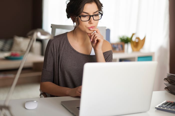 Woman at laptop deep in thought