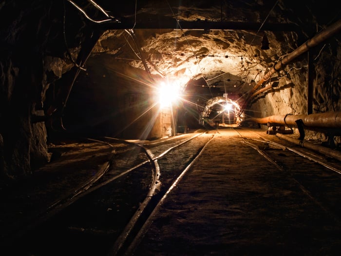 A mine tunnel with lights in the background