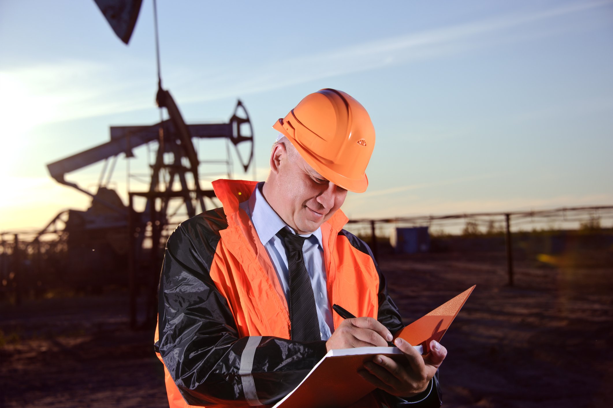 16_06_15 Man with notebook in front of oil well_XOM_BP_TOT_E_RDSB_CVX_GettyImages-156525694