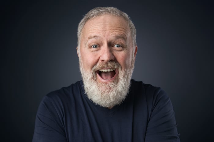 Bearded older man with big smile.