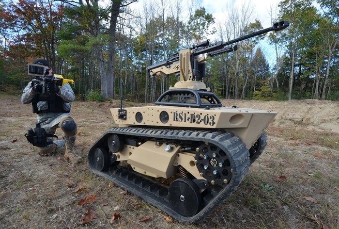 Howe & Howe autonomous land vehicle with a soldier nearby.