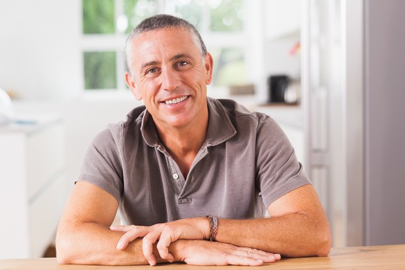Smiling middle-aged man sitting down at table