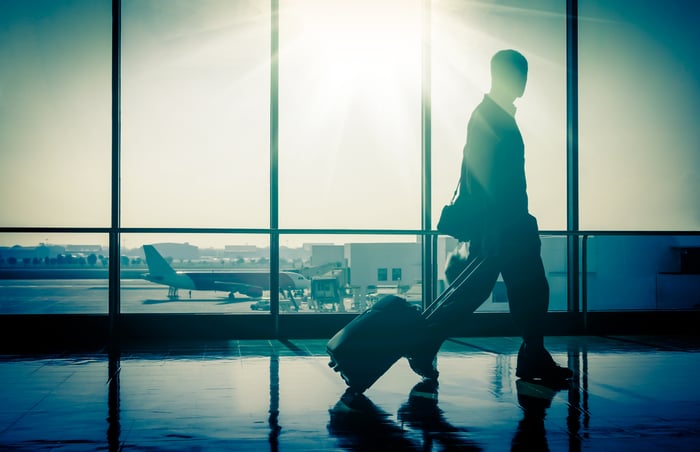 Man rolling suitcase through airport