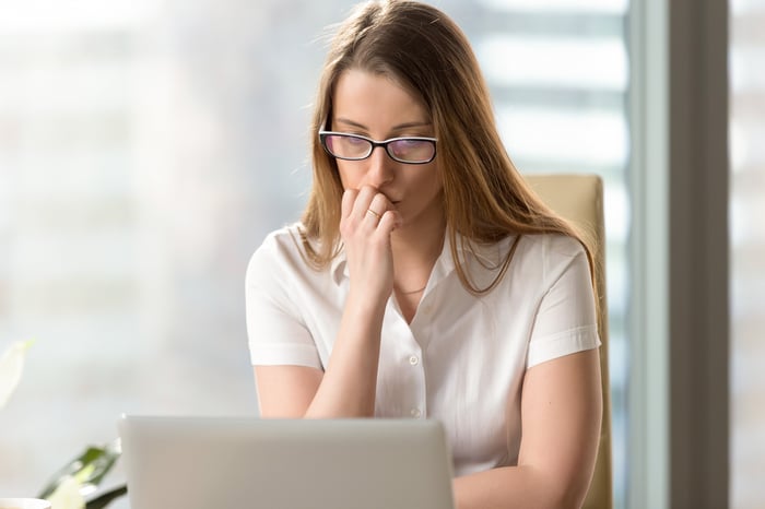 Woman at laptop with worried expression