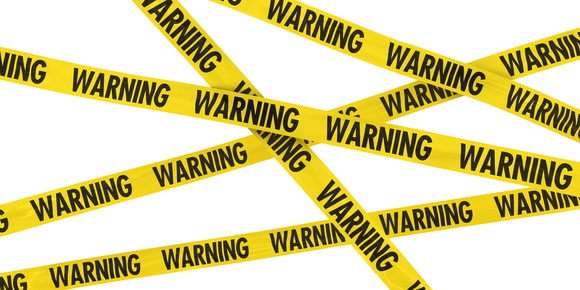Yellow tape with the word warning repeatedly printed on it is criss-crossed across the image, against a white background.