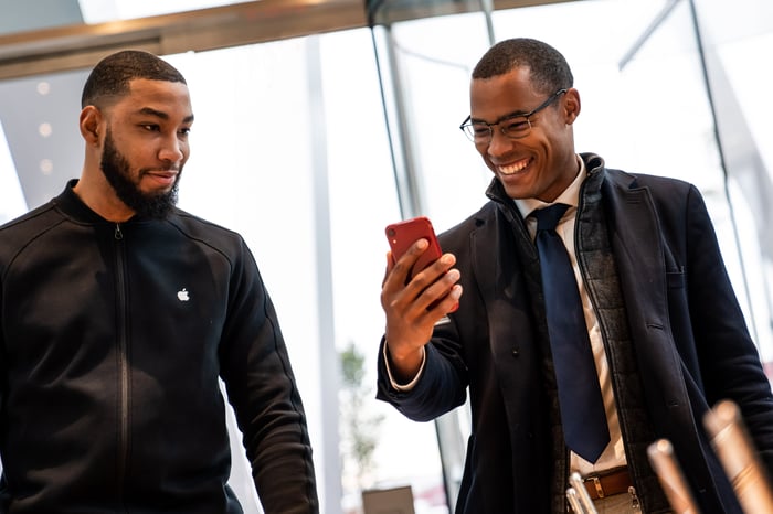 Customer holding a red iPhone XR at an Apple Store