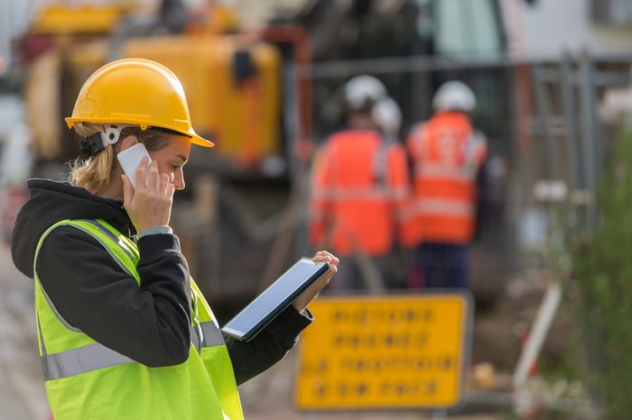 Female engineer using tablet device at construction site.