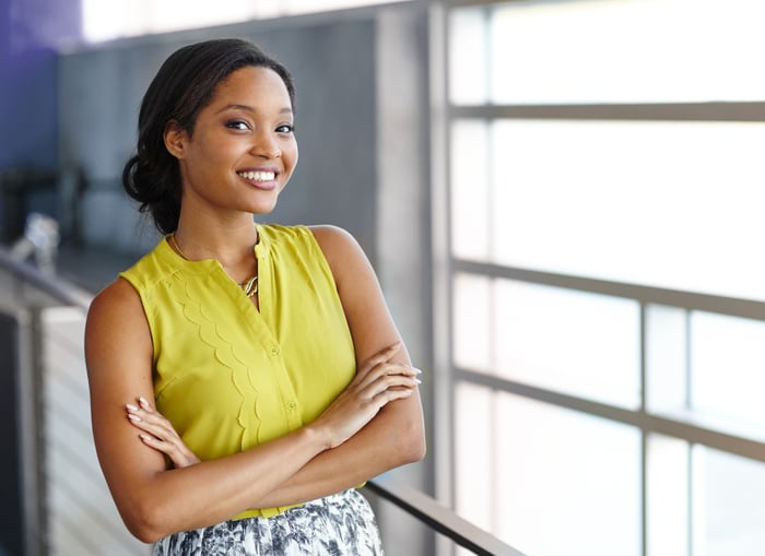 Smiling professionally dressed woman with arms crossed