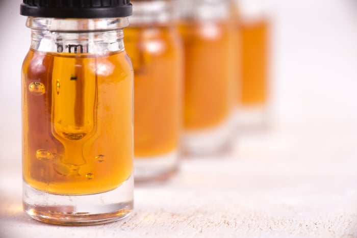 Four vials of cananbidiol oil lined up on a counter. 