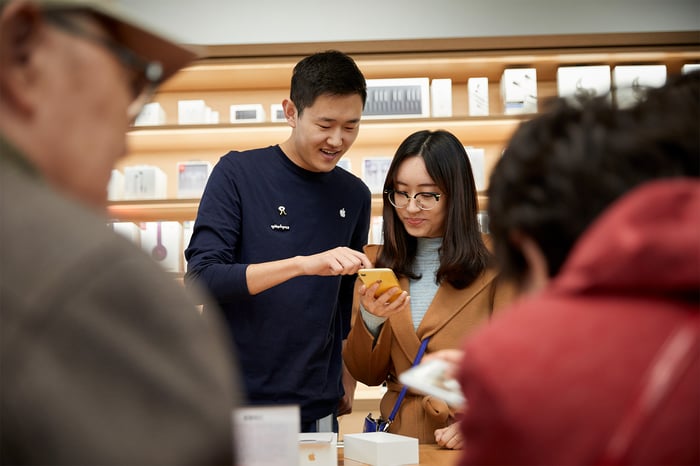 Retail employee showing a customer how to use an iPhone XR