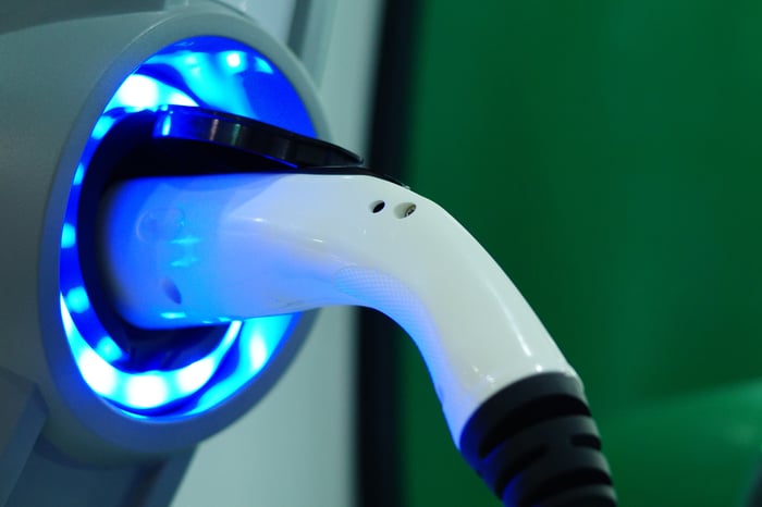 An electric car charger plugged into an electric car