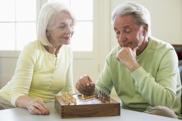 Senior woman and man playing chess