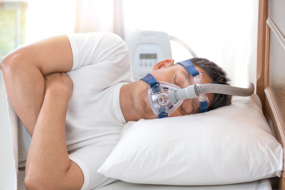 Sleeping man wearing CPAP mask.