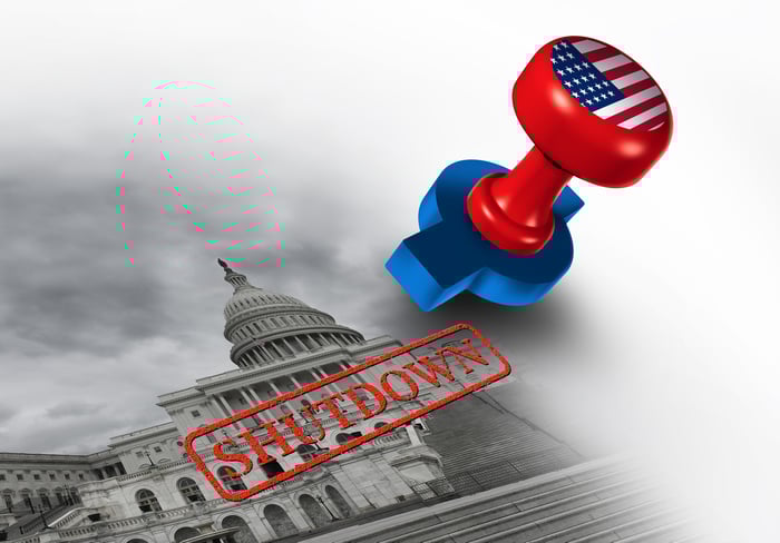 A stamp bearing the American flag imprinting the word, Shutdown, atop a black and white image of the Capitol building