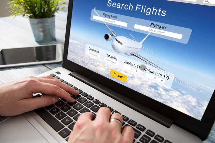 Man searching for flights on laptop.