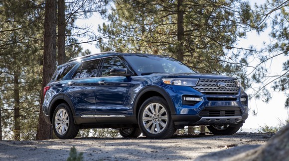 A blue 2020 Ford Explorer, a seven-passenger crossover SUV, parked in a wooded setting