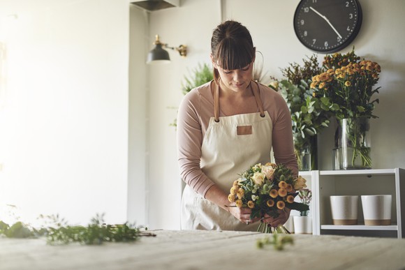 Woman working on floral arrangement