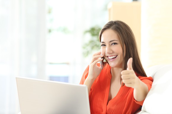 Woman talking on phone showing thumbs up