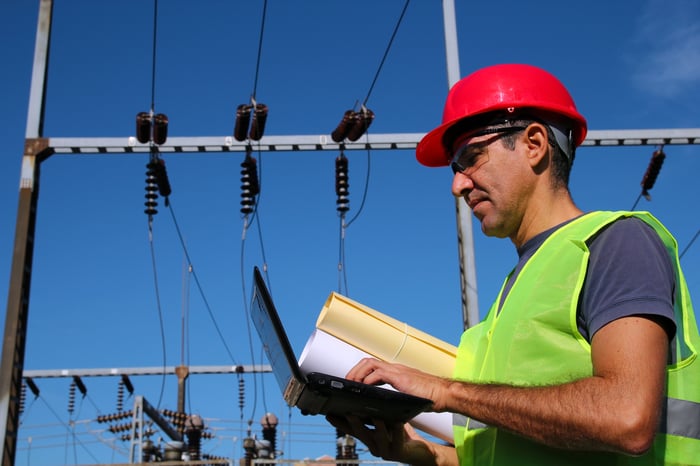 A man with high voltage power equipment behind him