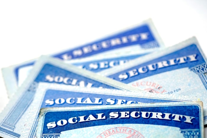 A half-dozen Social Security cards stacked in a messy pile atop one another. 