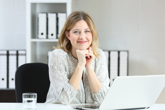 Smiling young woman at laptop.