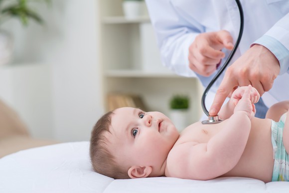 Baby being examined by a doctor.