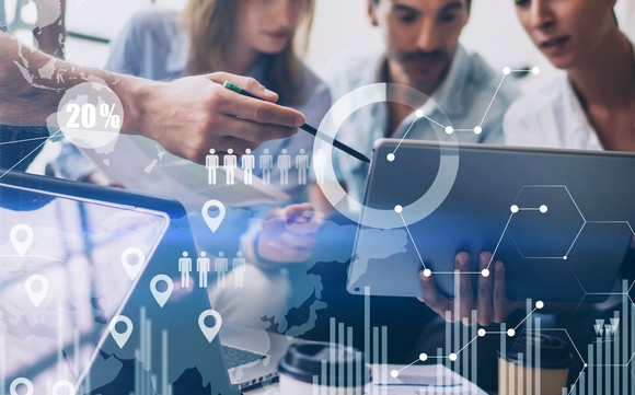 A picture of several employees gathered around a laptop