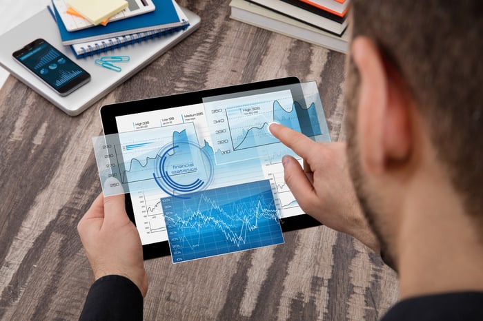 Man looking at stock charts on tablet computer