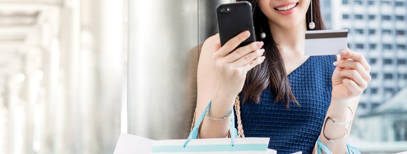 A young woman makes a purchase on her smartphone.
