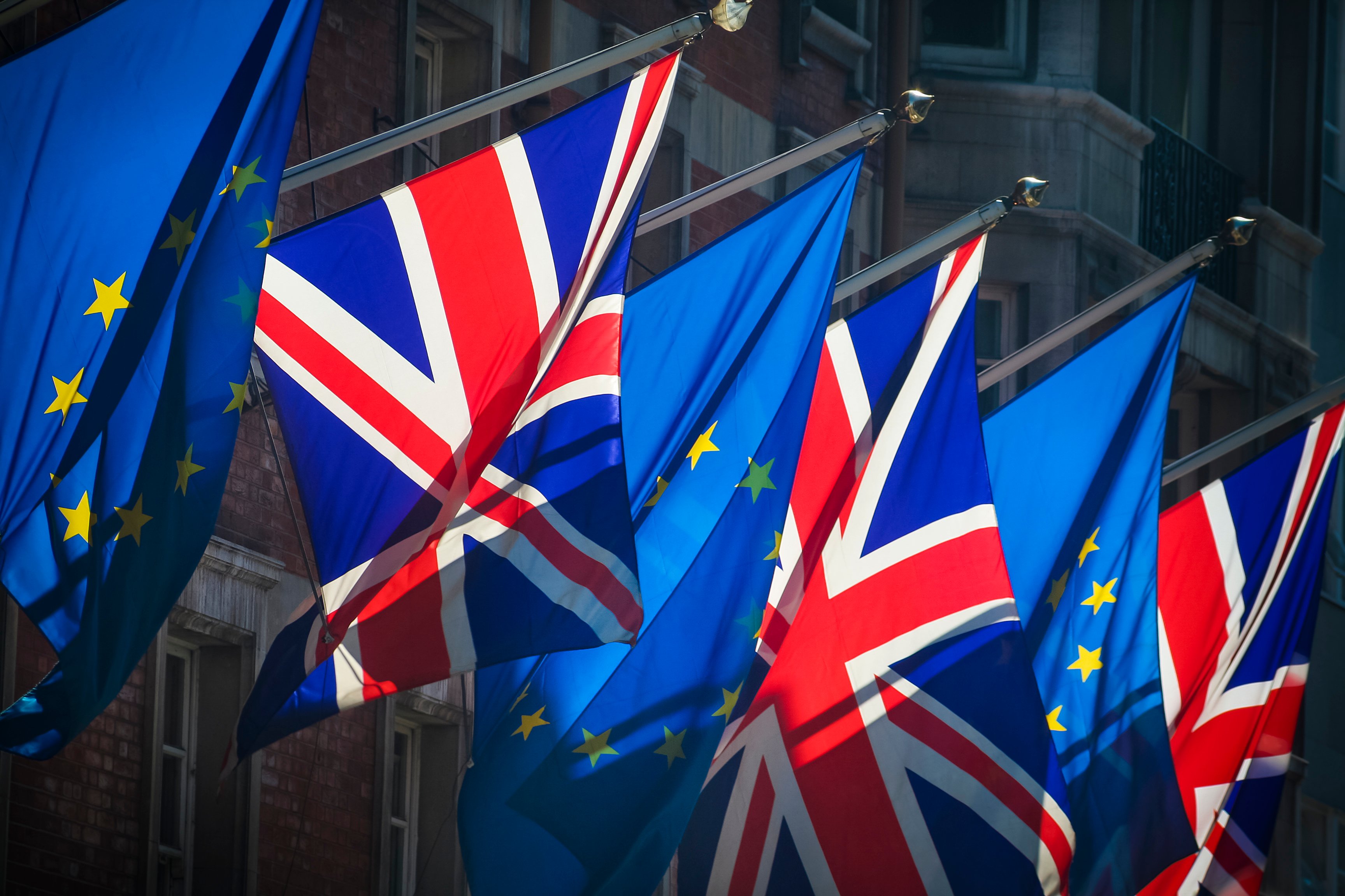 alternating United Kingdom and European Union flags hanging from building -- UK EU Brexit
