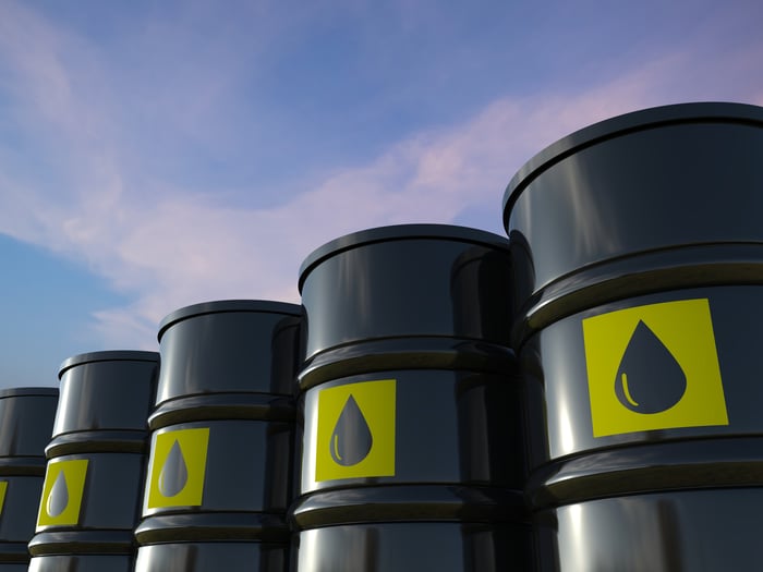 Black crude oil barrels lined up in a row. 