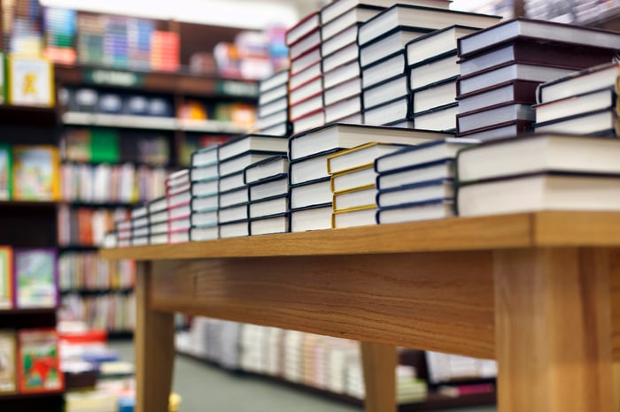 Books stacked on a table for sale at a bookstore.