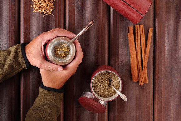 Man holding a yerba mate spice drunk in his hands.