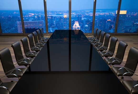 Empty boardroom table with a window overlooking a large city