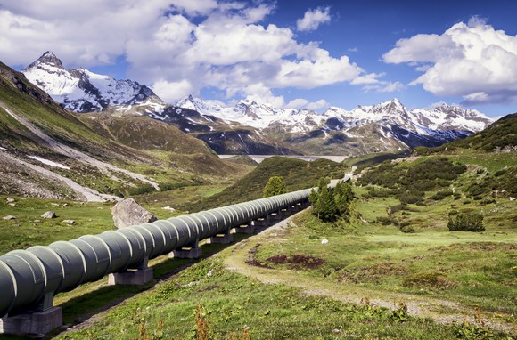 A pipeline with snow-capped mountains in the background