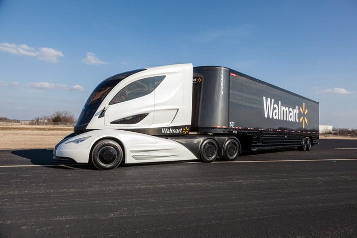 A modern-looking Walmart tractor-trailer making a turn on a desolate highway..