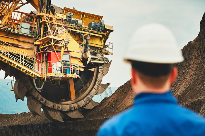 A man in a hard hat watching a coal mining machine