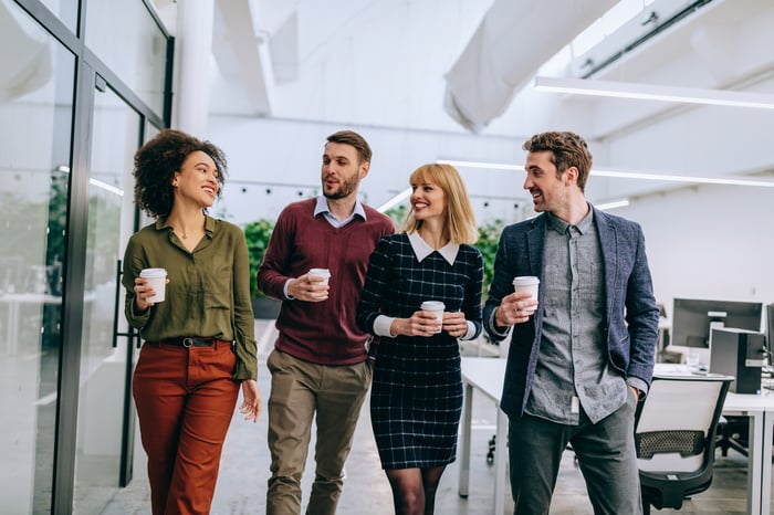 Two men and two women walking in an office