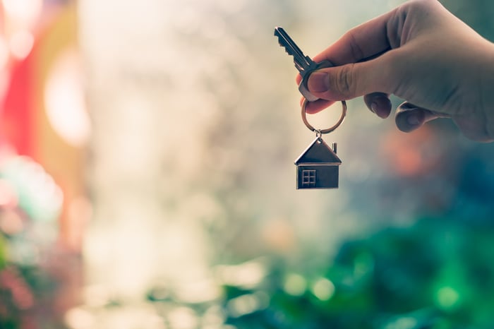 A person holds a key to a home in their hand.