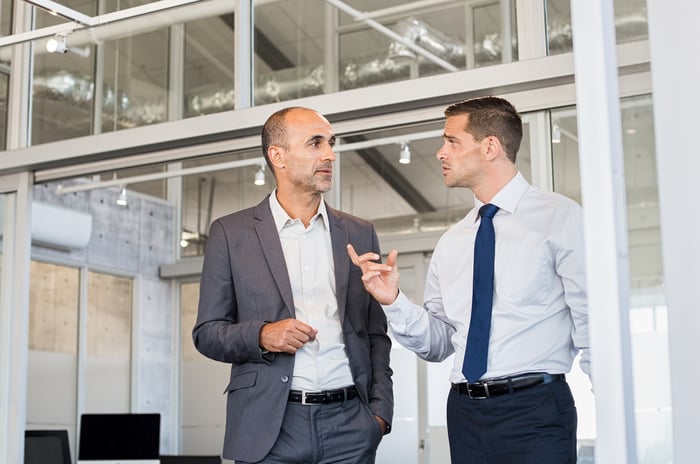 Two men in professional attire having a conversation