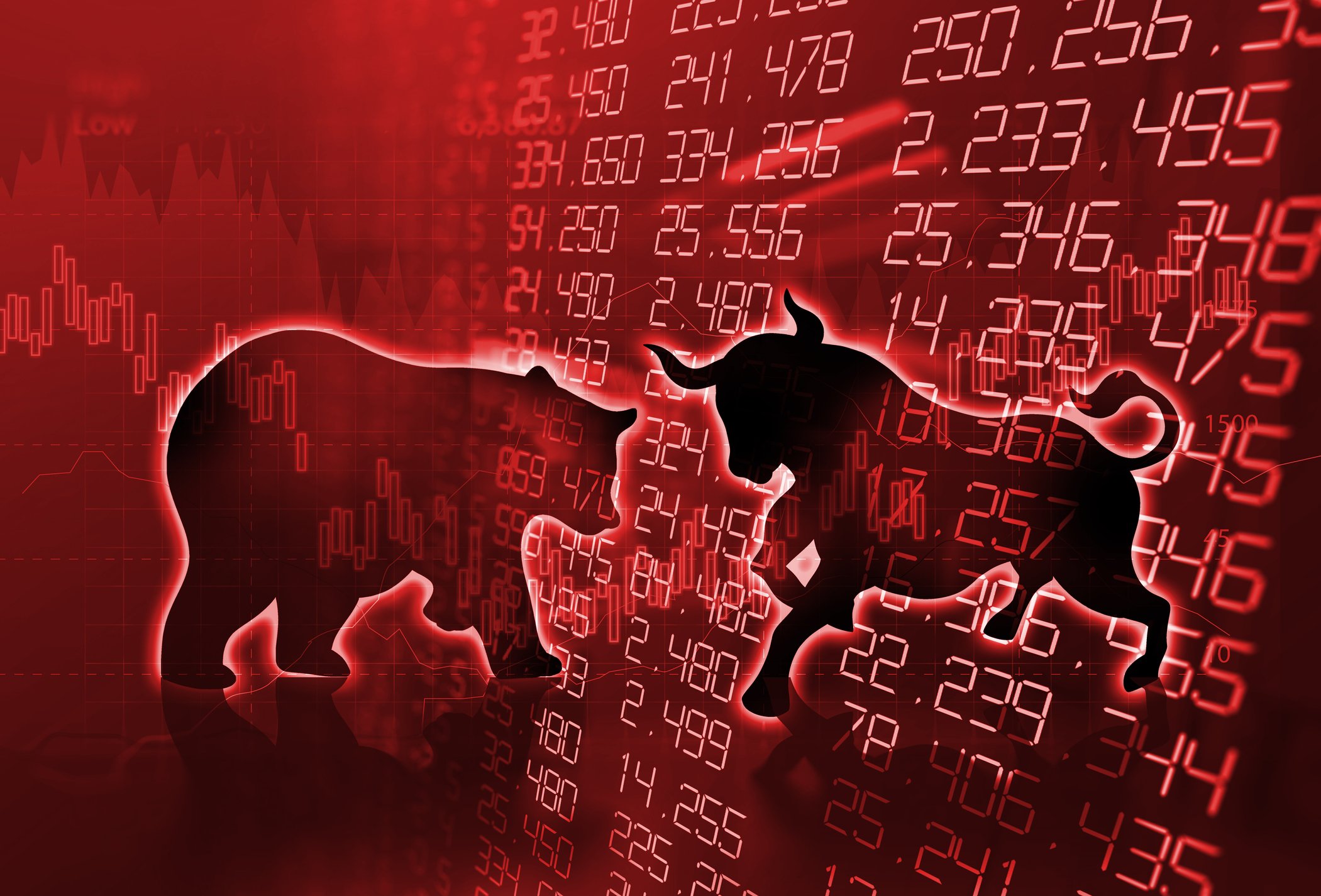 A red stock chart and screen with a bull and bear in front of it.