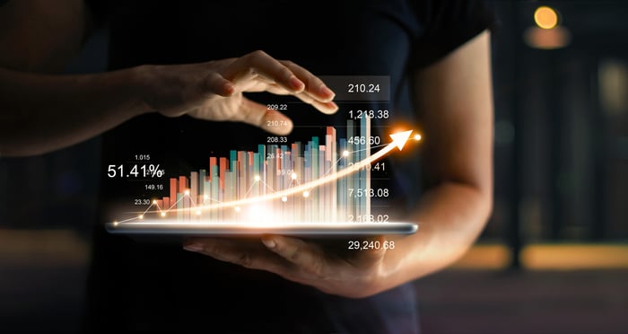 Woman's hands holding a notepad that's showing a hologram of a graph.