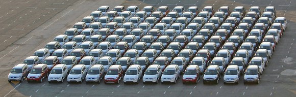 Cars parked in neat rows in a parking lot.