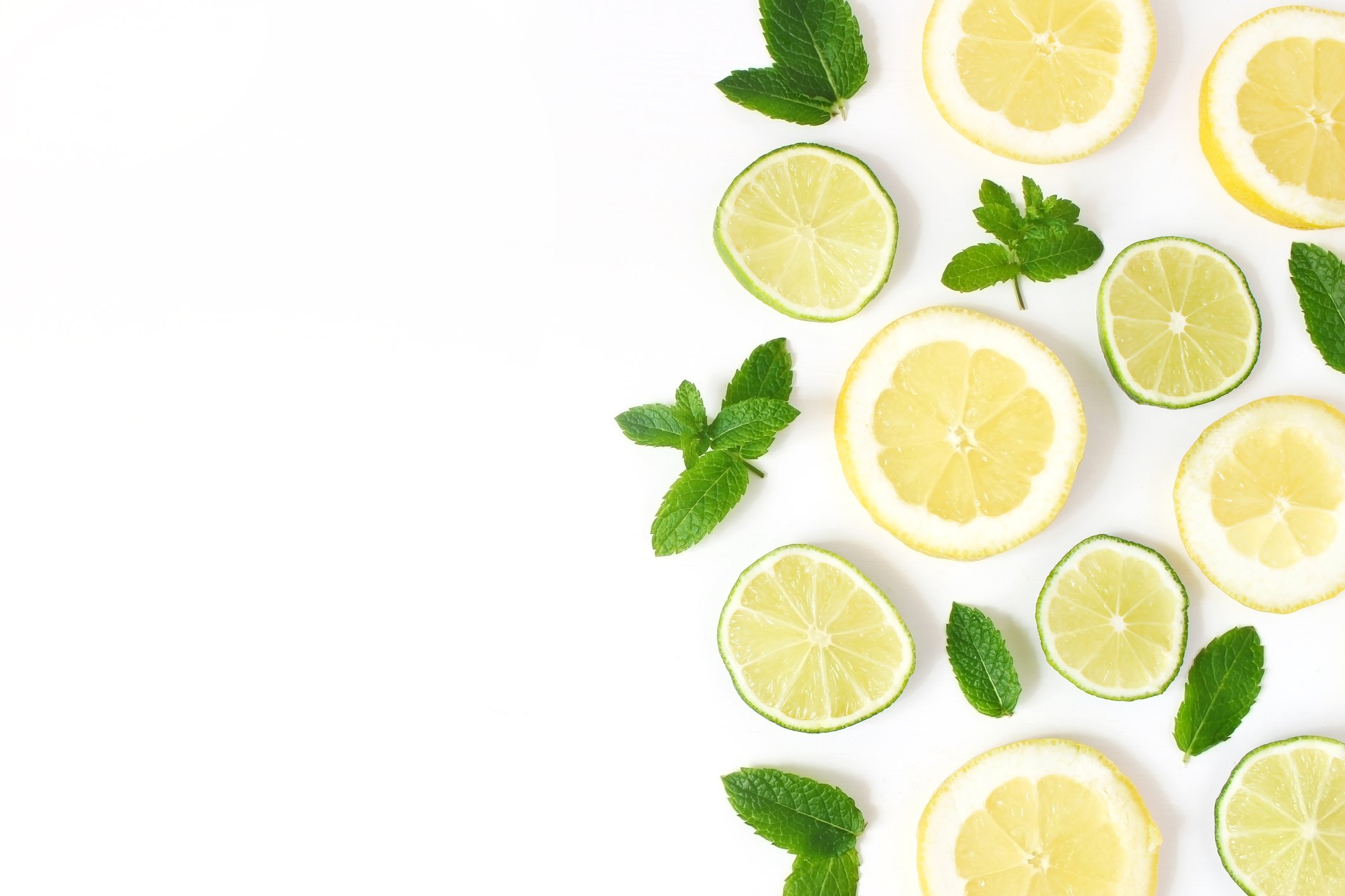 Sliced Lemons, Limes, and Mint Leaves on a White Tabletop