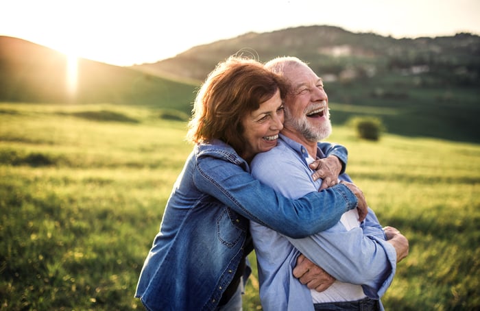 Smiling older man and woman embracing outdoors