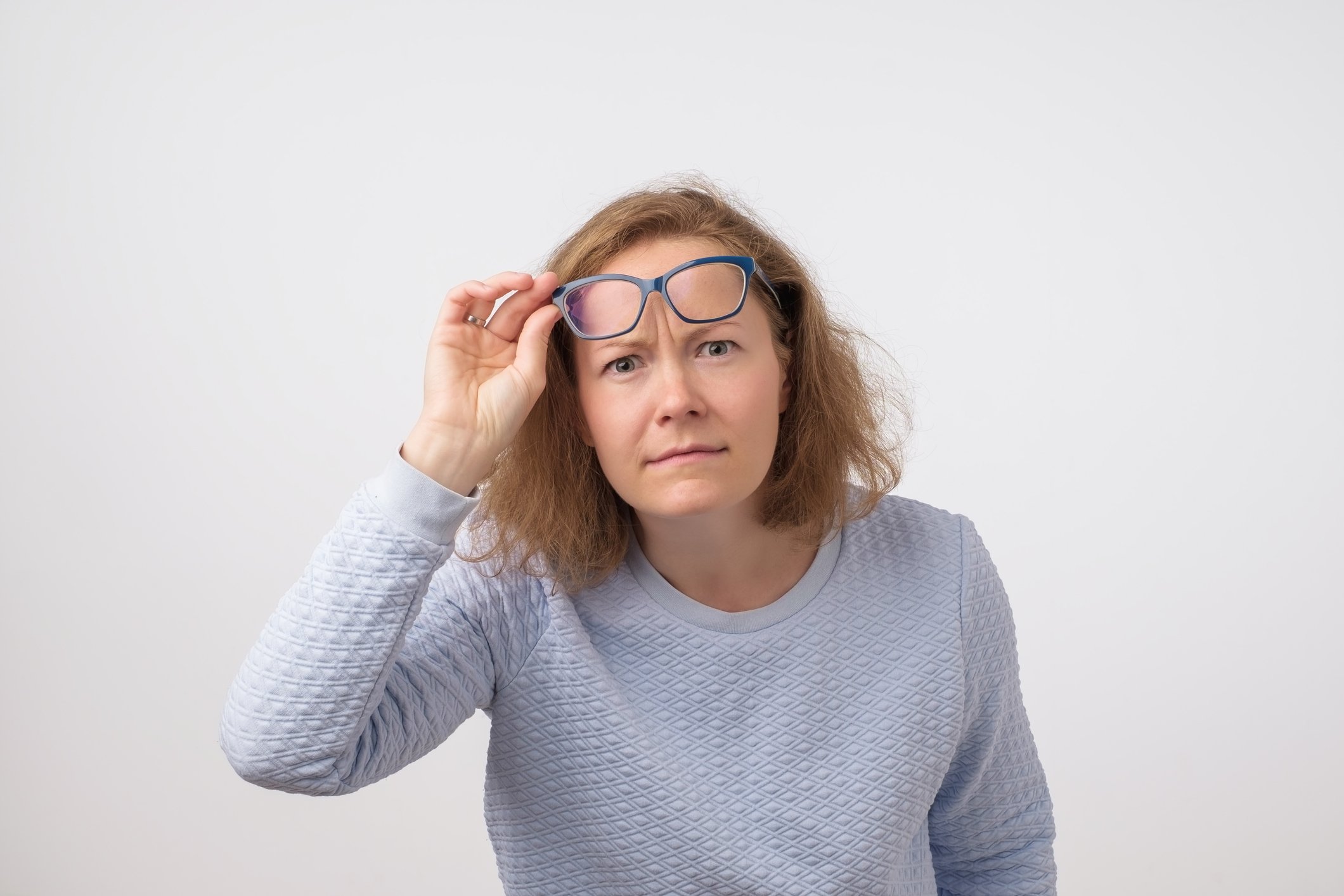 Woman removing glasses to look closely at something