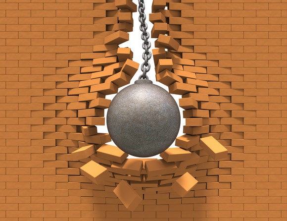 Wrecking ball going through a brick wall.