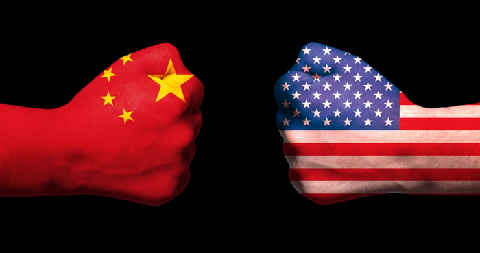 Two fists, emblazoned with Chinese and American flags, meet.