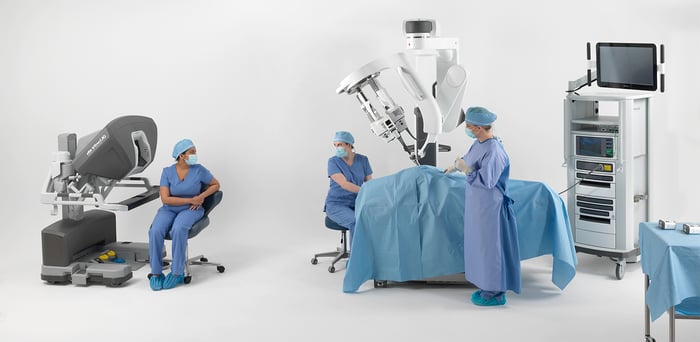 Surgeons in operating room with daVinci machinery