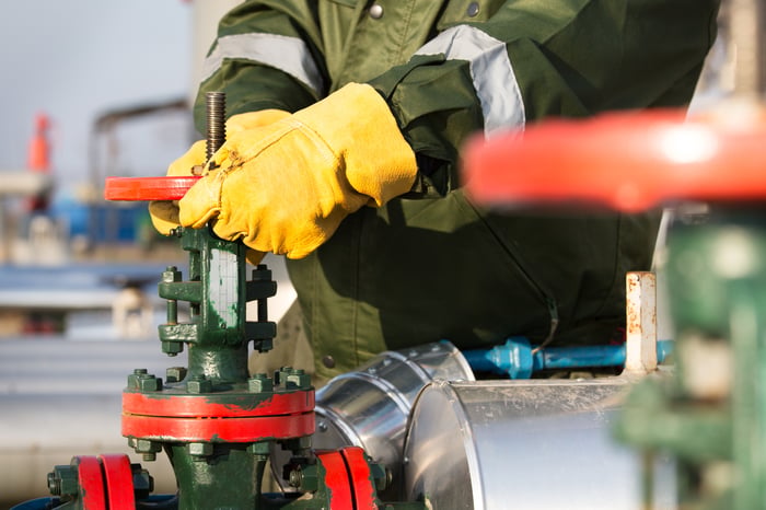 An oil worker turning a valve